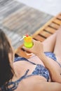 Young and beautiful girl at the pool with a cold cocktail close to her