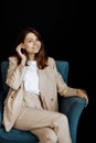 Young beautiful girl posing for a photo. Cute smiling looking at the camera while sitting in a chair in the studio. A Royalty Free Stock Photo