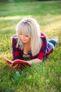 Young beautiful girl reading a book outdoor.