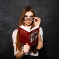 Young beautiful girl reading a book in the studio on a dark back Royalty Free Stock Photo