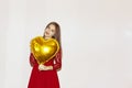 Young beautiful girl embracing heart shaped golden air balloon. valentines day, birthday, womens day, anniversary, holiday Royalty Free Stock Photo