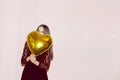 Young beautiful girl embracing heart shaped golden air balloon. valentines day, birthday, womens day, anniversary, holiday Royalty Free Stock Photo