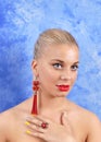 Young beautiful girl in red earrings on an abstract background Royalty Free Stock Photo