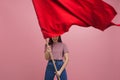 Young and beautiful girl with a red flag on a pink background. A socially active woman, to protest and fight for rights