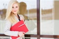 Young beautiful girl with a red folder and books Royalty Free Stock Photo