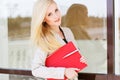 Young beautiful girl with a red folder and books Royalty Free Stock Photo