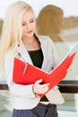 Young beautiful girl with a red folder and books Royalty Free Stock Photo