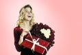 Young beautiful girl with a red gift with a white bow and flowers in her hands rejoices on an isolated white background. Valentine