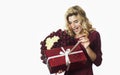 Young beautiful girl with a red gift with a white bow and flowers in her hands rejoices on an isolated white background. Valentine Royalty Free Stock Photo