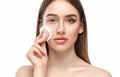 A young beautiful girl removes makeup with a cotton pad and micellar water from her face and eyes Royalty Free Stock Photo