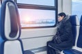 Young beautiful girl rides the train and looks out the window