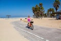 Young beautiful girl riding a bike down the Venice beach