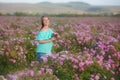 Young beautiful girl on a rose plantation