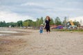 A young beautiful girl runs along a sandy beach in the sea with her son Royalty Free Stock Photo