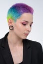 A young beautiful girl with short colored hair. Spread bright coloring and creative make-up. Piercing on the face. A