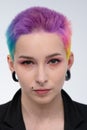 A young beautiful girl with short colored hair. Spread bright coloring and creative make-up. Piercing on the face. A