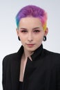 A young beautiful girl with short colored hair. Spread bright coloring and creative make-up. Piercing on the face. A