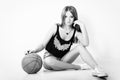 Young beautiful girl in shorts with the ball sits in the Studio on the white background