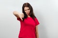 Young, beautiful girl showing a gesture with her hands thumbs down. Isolated on a light background. Different human emotions, Royalty Free Stock Photo