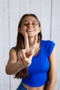 Young beautiful girl showing v gesture smiling over white wooden background. Royalty Free Stock Photo