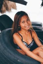 Young beautiful girl sitting in the truck tire on the beach Royalty Free Stock Photo