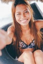 Young beautiful girl sitting in the truck tire on the beach Royalty Free Stock Photo