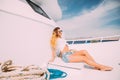 Young beautiful girl sitting on a yacht at sea relaxing on the water. Royalty Free Stock Photo
