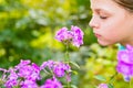 Young beautiful girl smells purple flowers in the garden Royalty Free Stock Photo