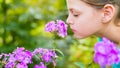 Young beautiful girl smells purple flowers in the garden Royalty Free Stock Photo