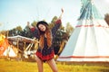 Young beautiful girl smiling on background teepee, tipi- native indian house. Pretty girl in hat with long cerly hair Royalty Free Stock Photo