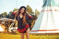 Young beautiful girl smiling on background teepee, tipi- native indian house. Pretty girl in hat with long cerly hair Royalty Free Stock Photo