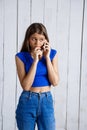 Young beautiful girl smiling talking on phone over white wooden background. Royalty Free Stock Photo