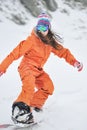 Young beautiful girl snowboarder in motion