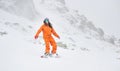 Young beautiful girl snowboarder in motion