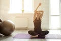 Young girl in sportswear doing yoga at home on self-isolation, an athlete sits in a lotus position and meditates in a loft room Royalty Free Stock Photo