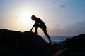 The young beautiful girl the sportswoman, in sportswear sneakers jumps through rocks at sunset, a high jump, physical training, fi Royalty Free Stock Photo