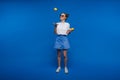 A young beautiful girl standing on a blue background holding lemons in her hand. Smiles Royalty Free Stock Photo