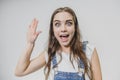 A young beautiful girl stands on a gray background. It is dressed in an orange helmet on the head. Royalty Free Stock Photo