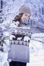 A young beautiful girl stands in a snowy forest. The girl is dressed in a warm sweater Royalty Free Stock Photo