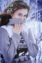 A young beautiful girl stands in a snowy forest. The girl is dressed in a warm sweater Royalty Free Stock Photo