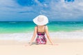 Young beautiful girl in a straw white hat back to the viewer on Royalty Free Stock Photo