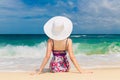 Young beautiful girl in a straw white hat back to the viewer on Royalty Free Stock Photo