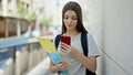 Young beautiful girl student using smartphone with serious face at school Royalty Free Stock Photo