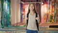 Young beautiful girl student wearing backpack looking around smiling at art gallery Royalty Free Stock Photo