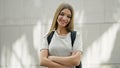 Young beautiful girl student wearing backpack standing with arms crossed gesture smiling over isolated white background Royalty Free Stock Photo