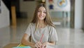 Young beautiful girl student writing on paper smiling at library Royalty Free Stock Photo