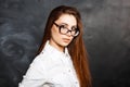 Young beautiful girl in stylish glasses and a white blouse fashion on a dark background in the studio. Office Style Royalty Free Stock Photo