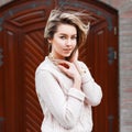 Young beautiful girl in a sweater on the background of the door. Royalty Free Stock Photo