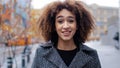 Young beautiful girl teenager millennial African American woman with curly hair stands in city on street suffers from Royalty Free Stock Photo