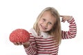 Young beautiful girl 6 to 8 years old playing with rubber brain having fun learning science concept